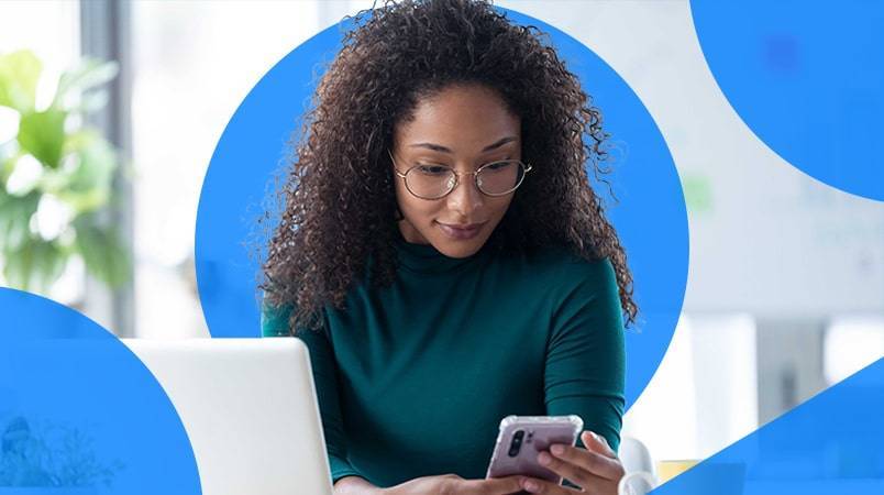 Woman working on laptop and phone
